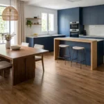 Cocina de diseño moderno abierta al comedor con suelo vinílico de imitación madera premium de la marca Arbiton, mostrando su resistencia al agua y continuidad visual sin juntas.